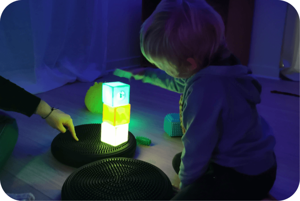 Enfant qui joue à empiler des cubes lumineux